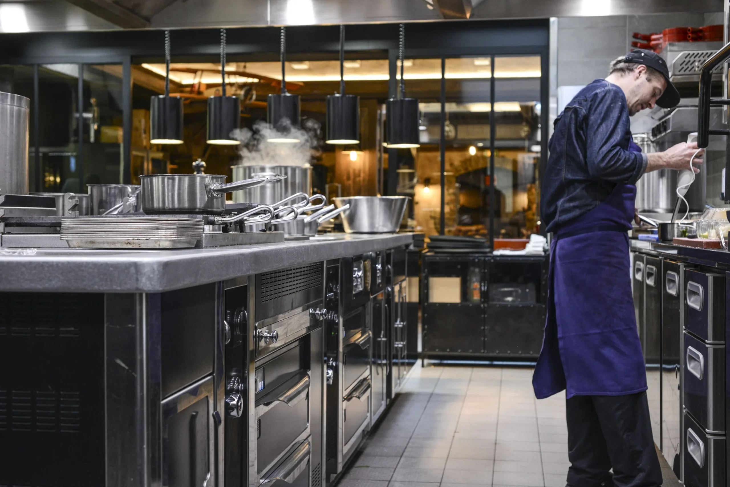 Un cuisinier au travail dans une cuisine professionnelle illustre l’emploi à Méribel à l’Hôtel La Chaudanne.