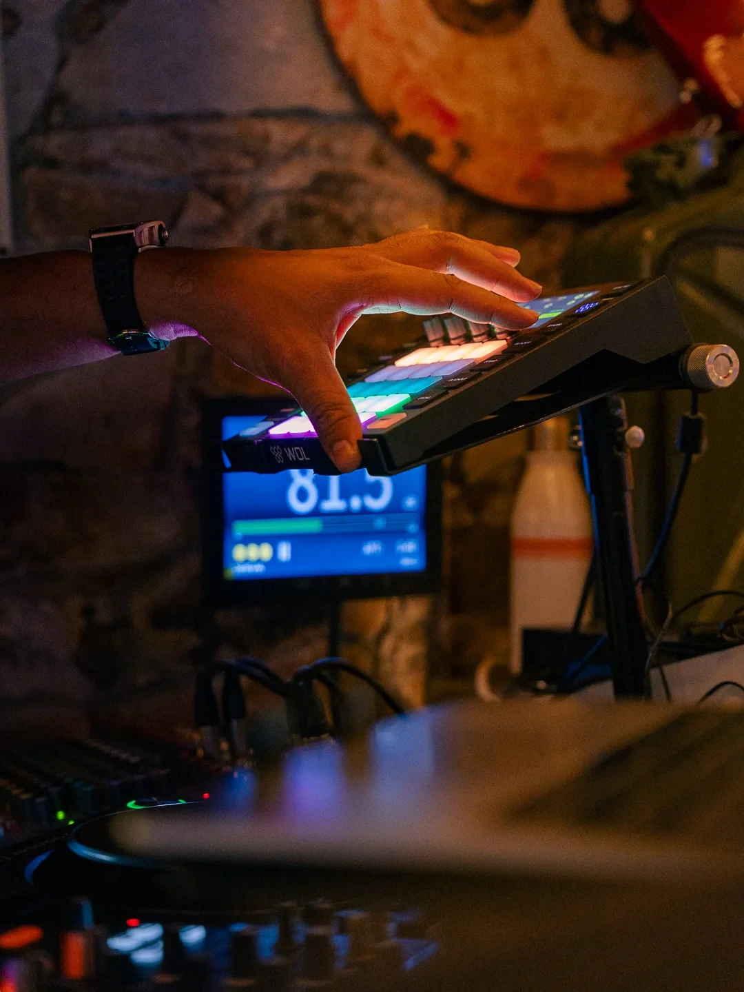 Une main actionne les touches lumineuses d’un contrôleur musical électronique.