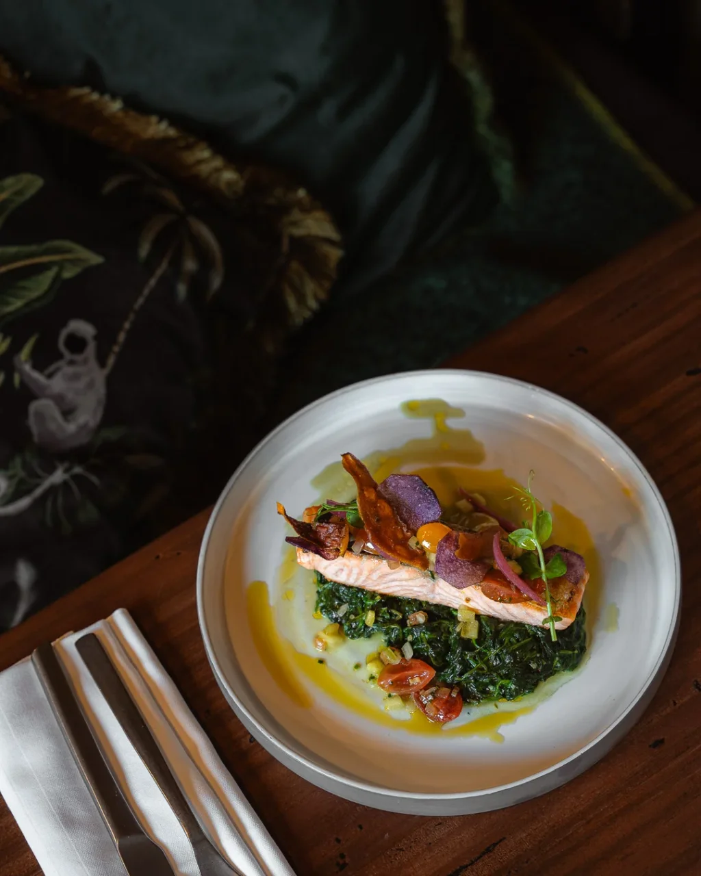 Pavé de saumon sur un lit d’épinards, garni de chips colorées et de jeunes pousses au restaurant Le 80 de l’Hôtel La Chaudanne.
