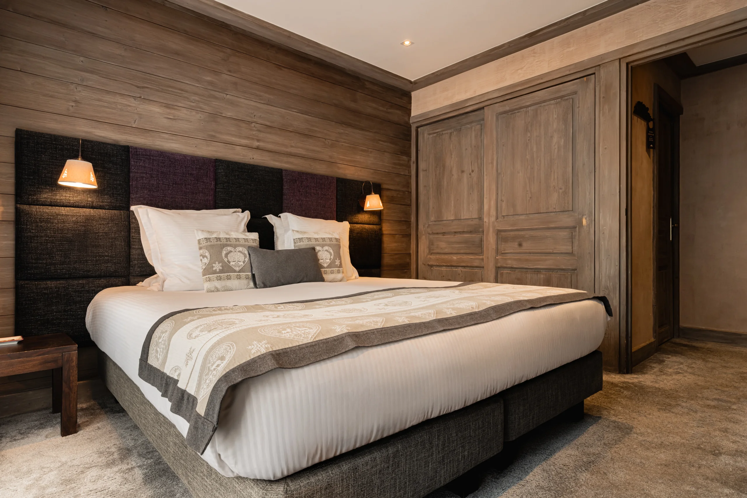 Chambre avec lit double et boiseries à l’Hôtel La Chaudanne, hôtel 4 étoiles à Méribel.