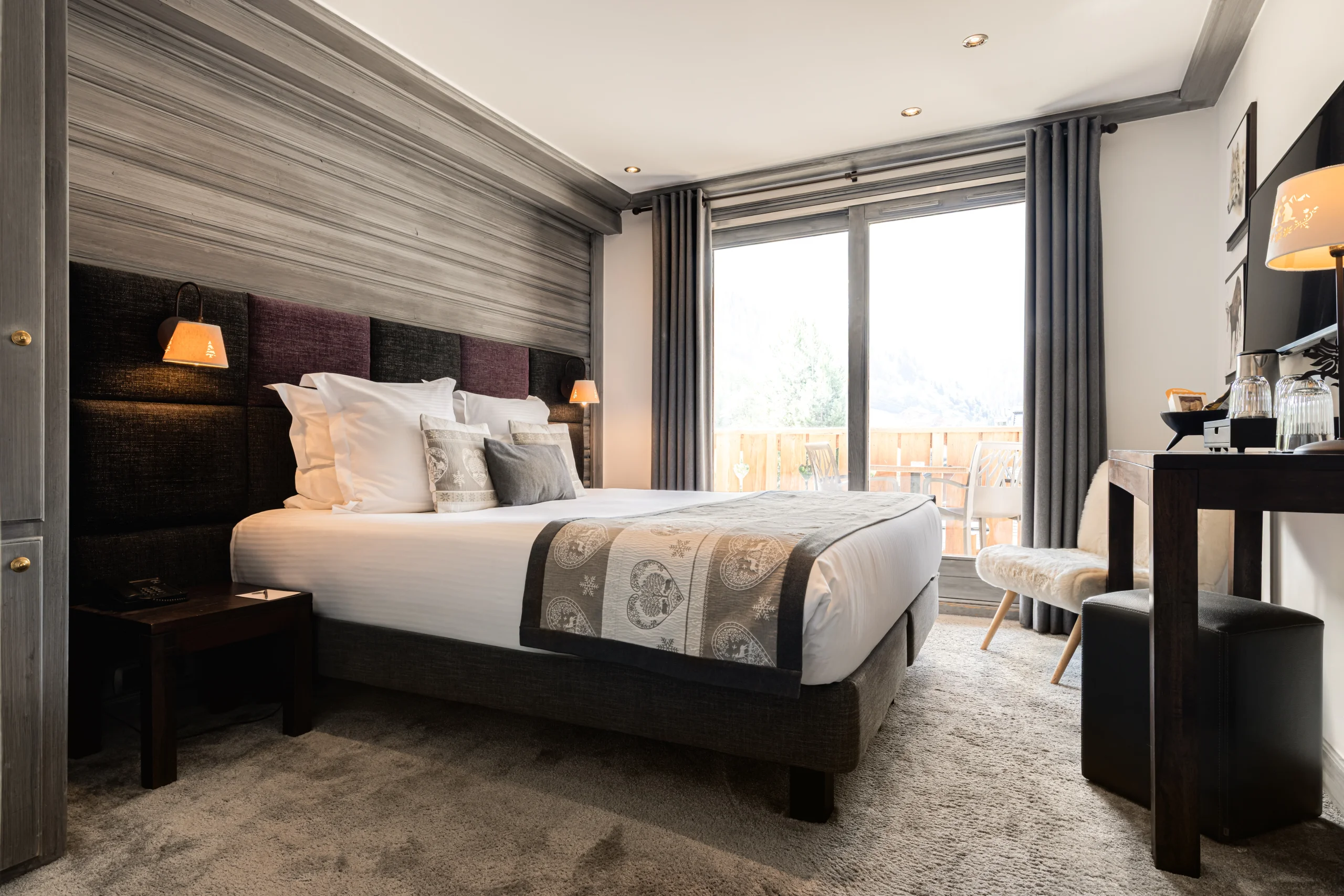 Chambre avec lit double et balcon à l’Hôtel La Chaudanne, hôtel 4 étoiles à Méribel.