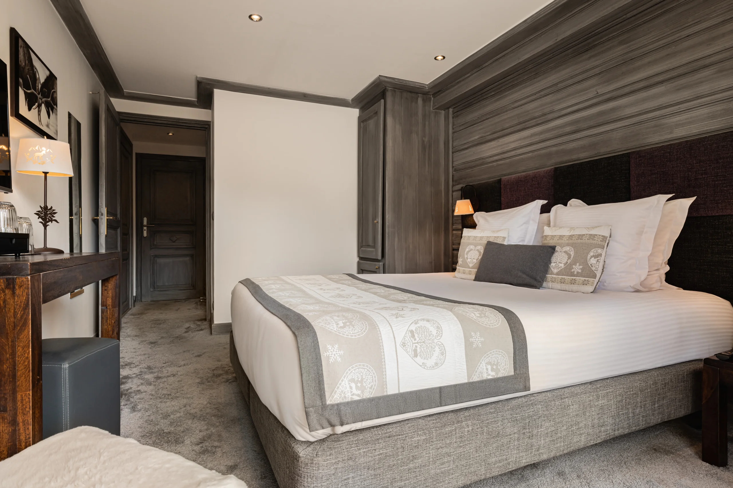 Chambre avec lit double, bureau en bois et armoire intégrée à l’Hôtel La Chaudanne.