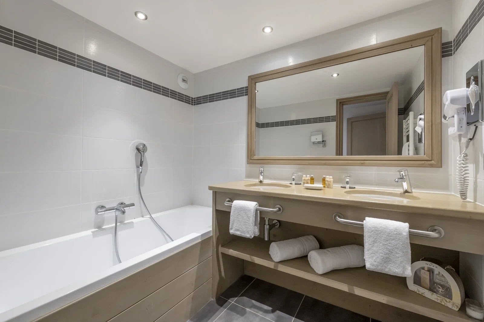 Salle de bains avec baignoire et double vasque à l’Hôtel La Chaudanne, hôtel 4 étoiles à Méribel.