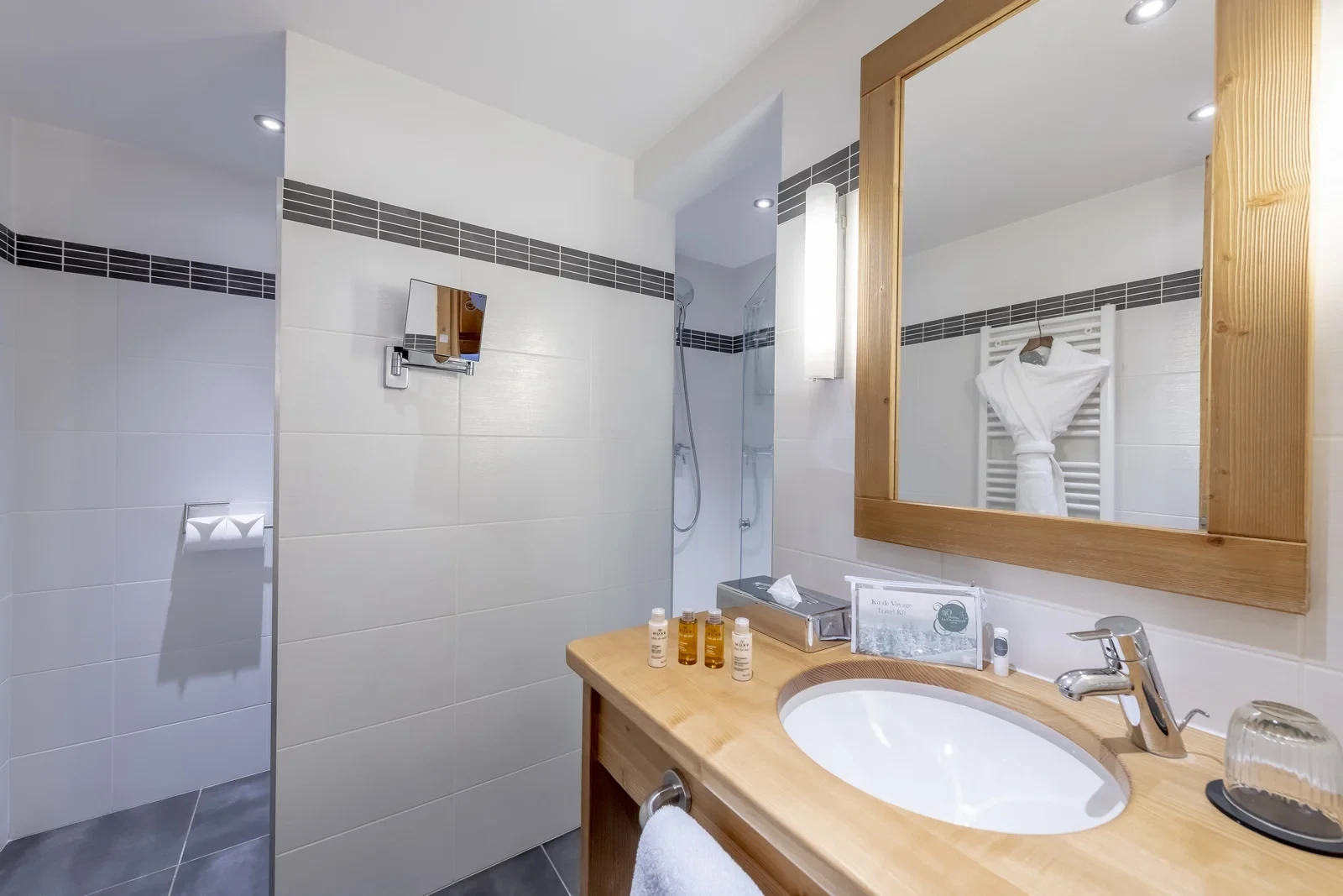Salle de bain avec douche vitrée et vasque sur meuble en bois à l’Hôtel La Chaudanne, hôtel 4 étoiles à Méribel.