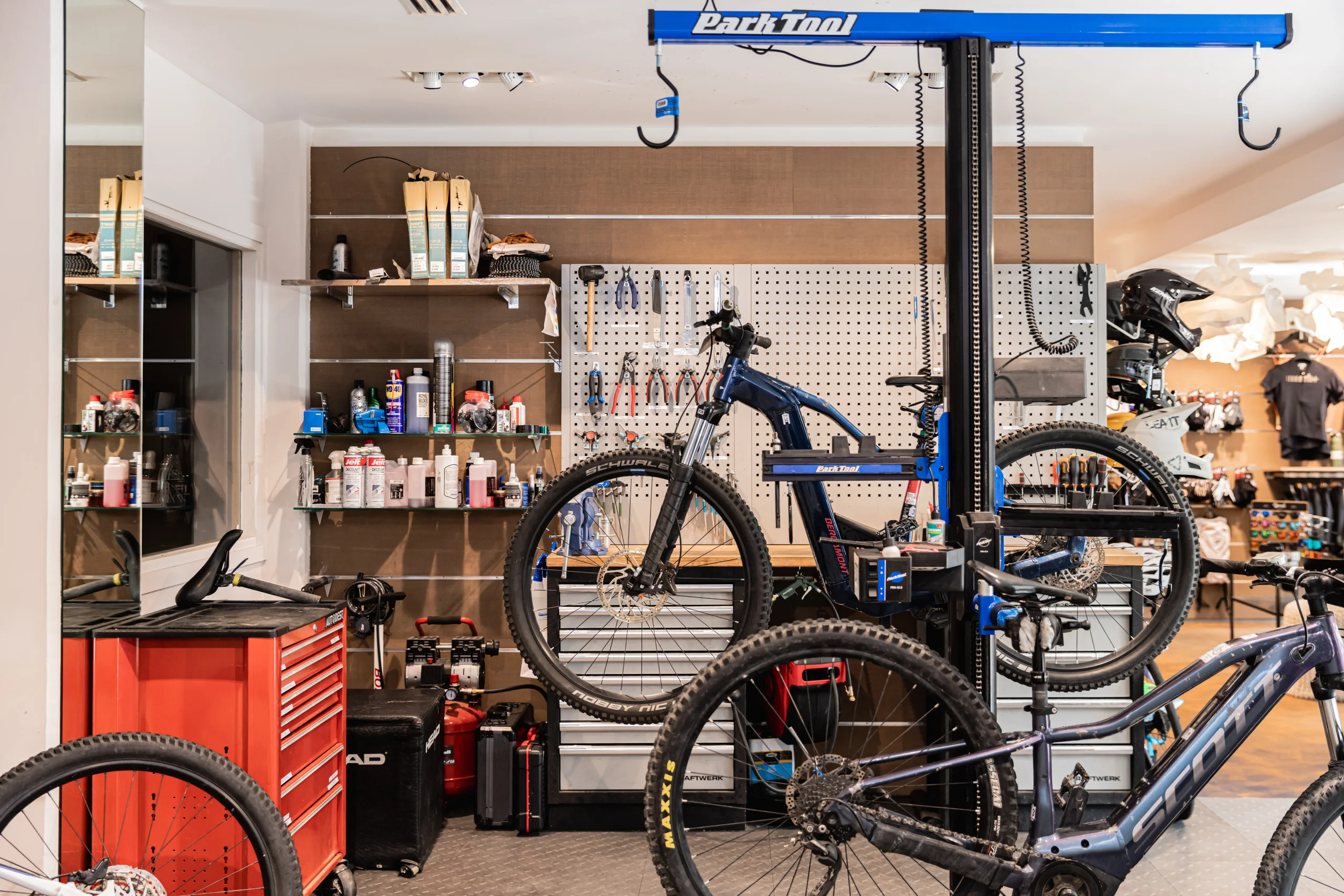 Atelier du bike shop l’Eskale de l’Hôtel La Chaudanne, dédié à la location de VTT à Méribel, avec vélos sur supports et établi outillé.