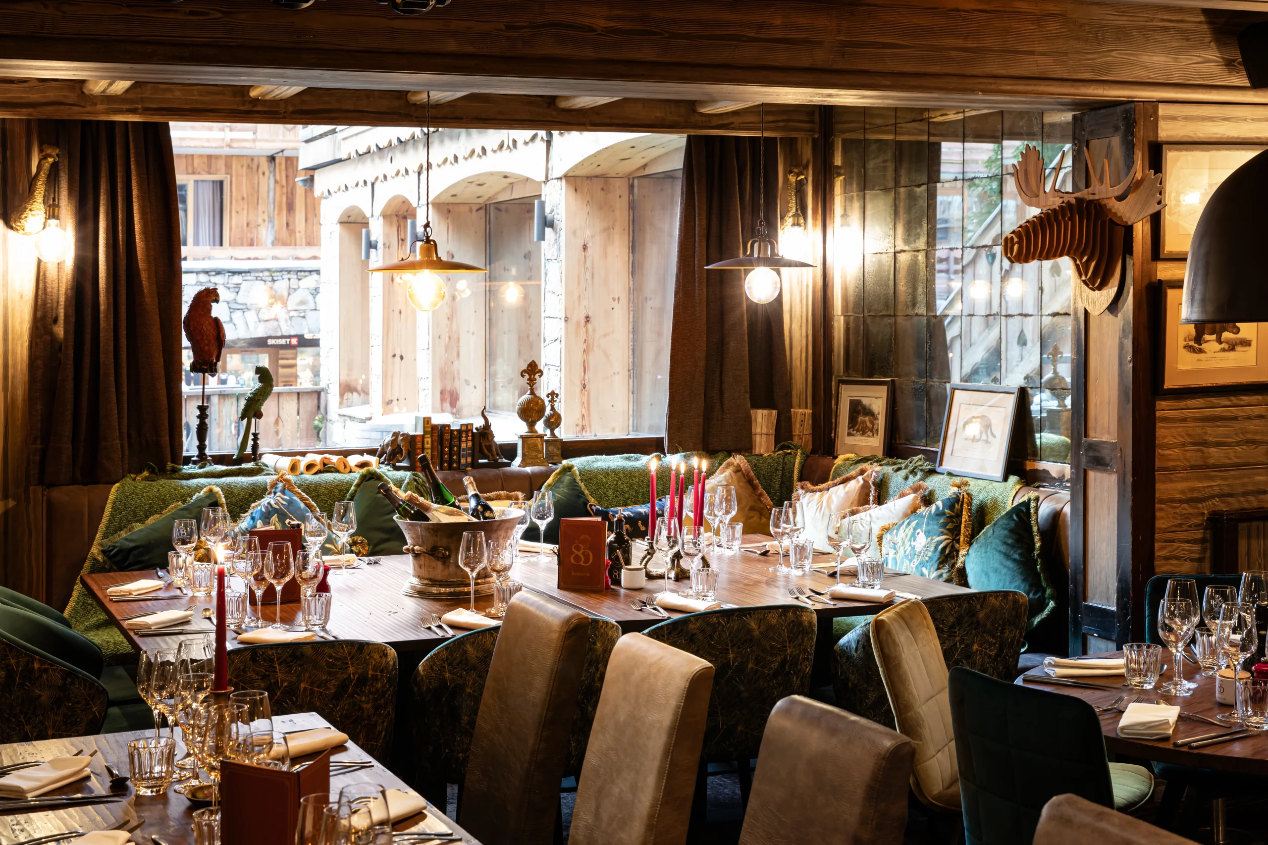 Tables dressées dans la salle boisée de l’Hôtel La Chaudanne, qui propose un restaurant à Meribel et un bar à Méribel.