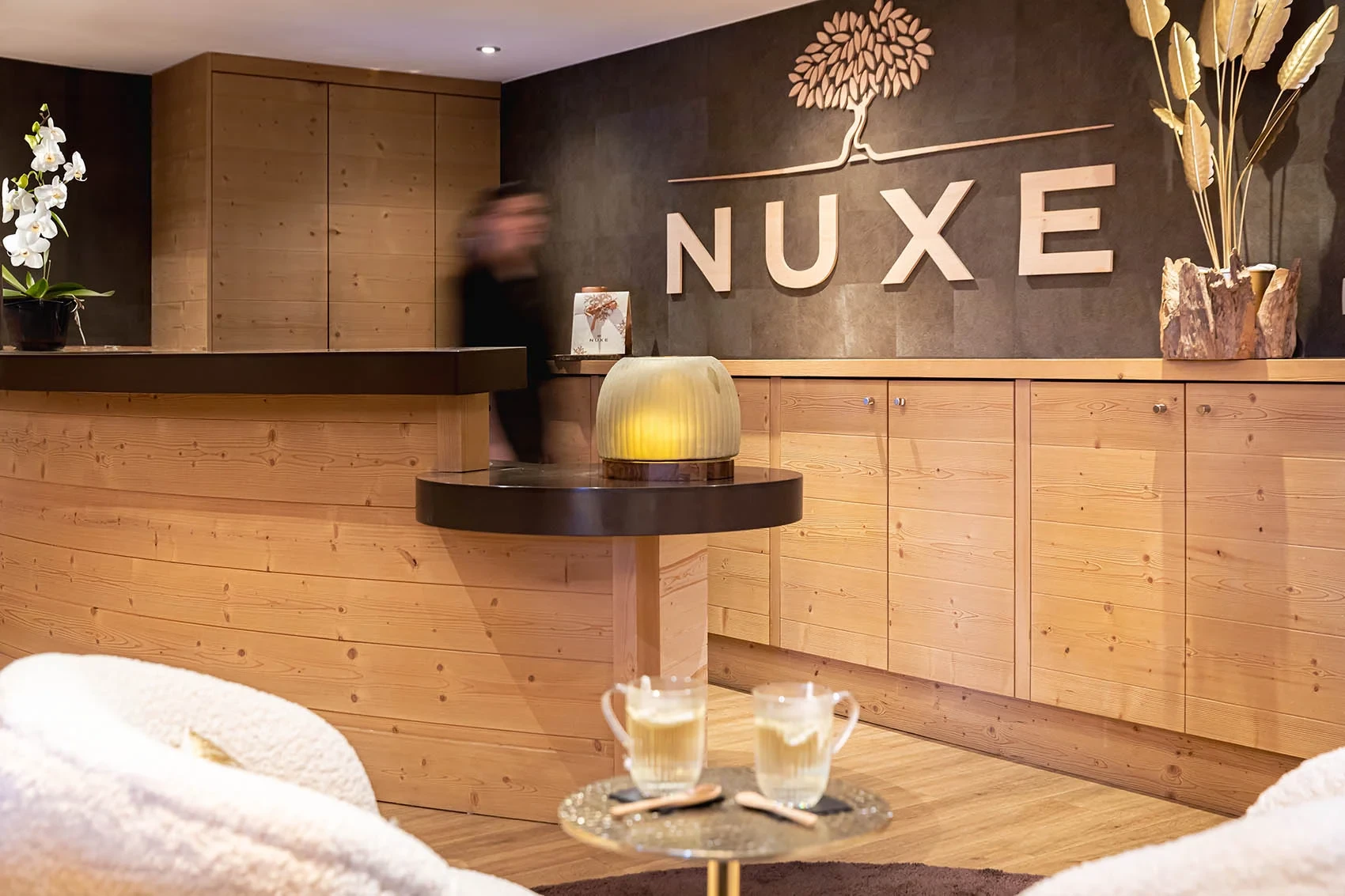 Accueil du spa à Méribel, avec comptoir en bois et enseigne NUXE.
